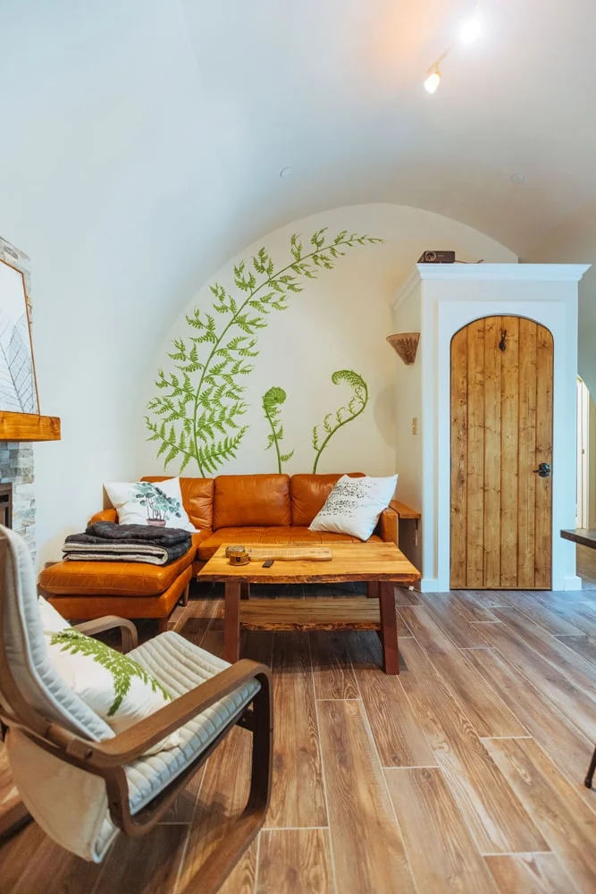 Warm interior of Fern Hollow with curved walls, natural wood, stone, and nature-inspired details.