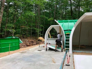 Green curved shell sections assembled to form The Shire hobbit house in Maine.