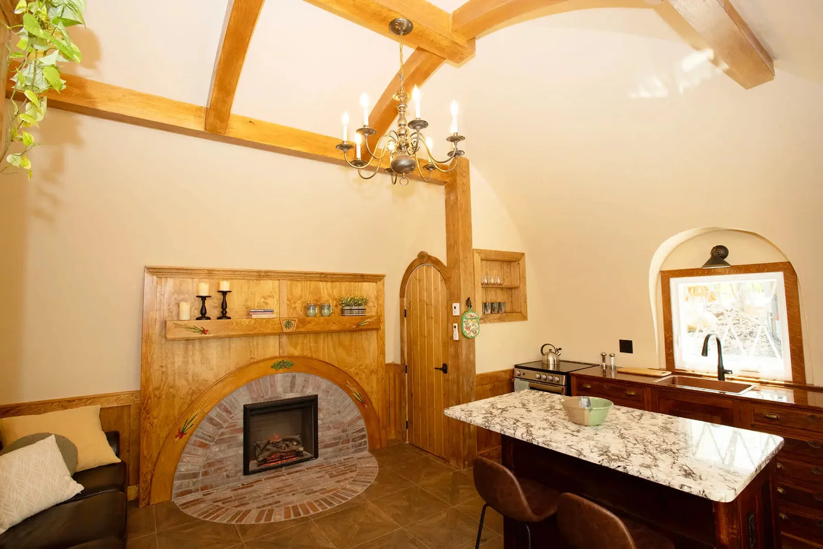 Interior of The Shire with a hand-painted hearth, arched beams, and warm storybook details.